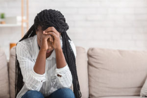A teen sits with her hands together against her head hiding her face. Learn how a trauma therapist in Delray Beach, Fl can help teens and families cope with traumatic events. Learn more about trauma therapy in Delray Beach, FL, and the support a grief counselor in Palm Beach County, Fl can offer. 