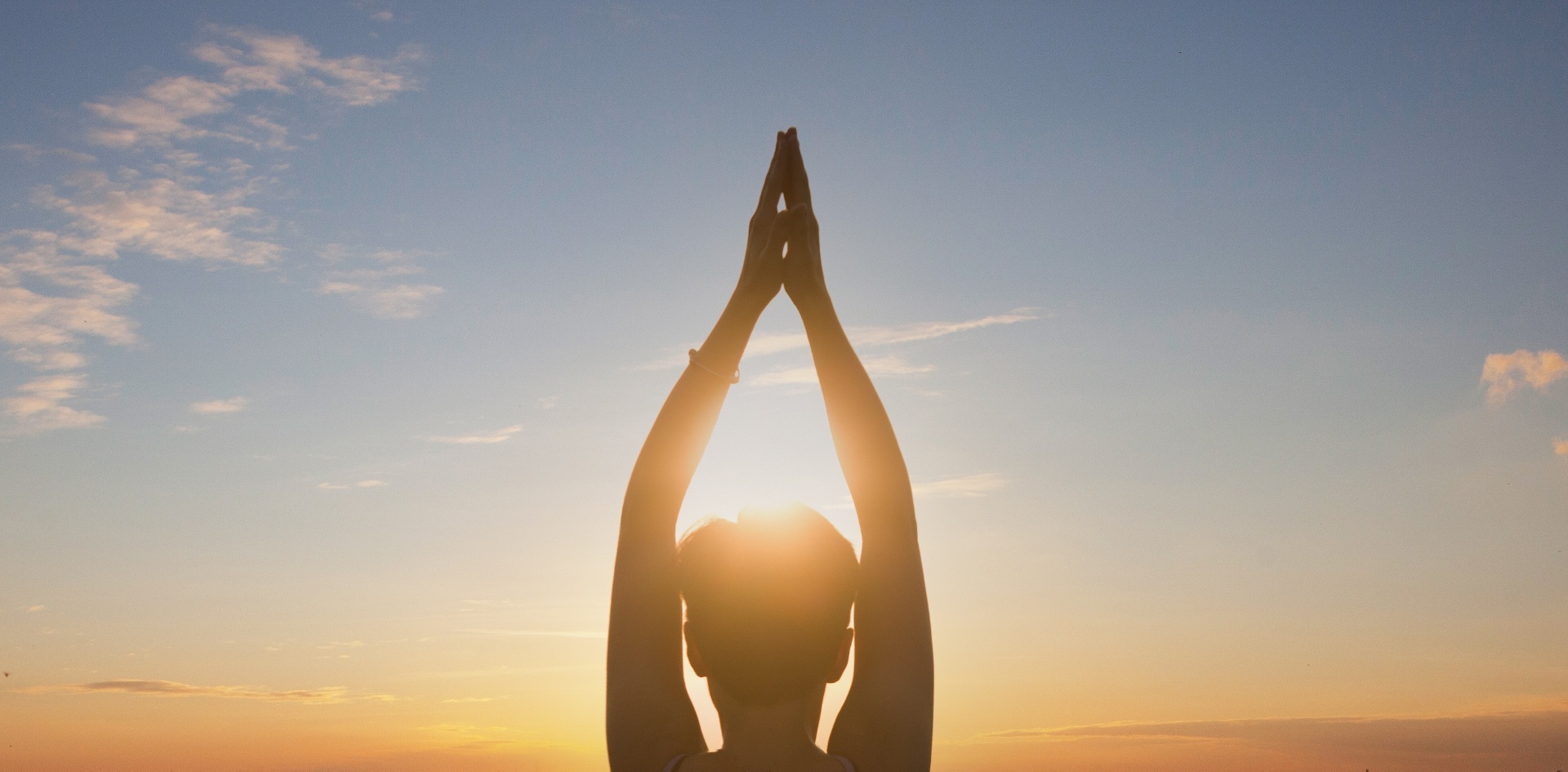 A person stands with their hands above their head as they look towards the setting sun. This could represent the calm and joy a trauma therapist in Palm Beach, FL and help you achieve. Learn more about trauma therapy in Palm Beach, FL by contacting a trauma therapist in Miami, FL today. 