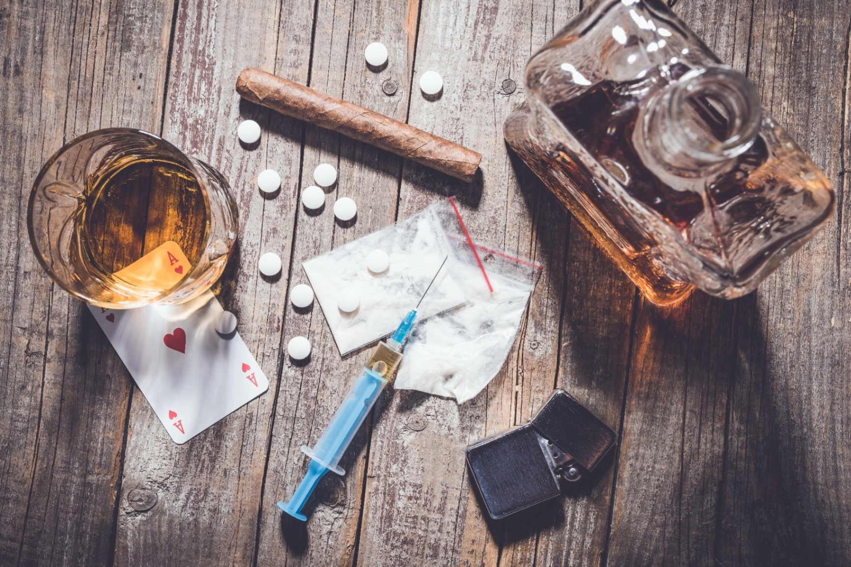 A top down view of drugs and alcohol of different kinds. Addiction counseling in Palm Beach, FL can help you overcome different types of addition in Palm Beach. Learn more about addiction counseling in Delray Beach, FL by contacting an addiction therapist in Palm Beach, FL today. 