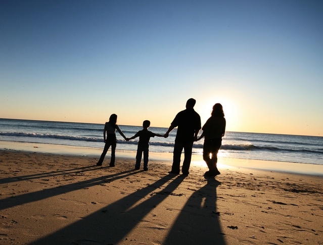 A family of four hold hands while walking against the shore of a beach. Learn how substance abuse counseling in Palm Beach, FL can offer support with substance use disorder symptoms. An addiction therapist in Palm Beach, FL can offer support today!