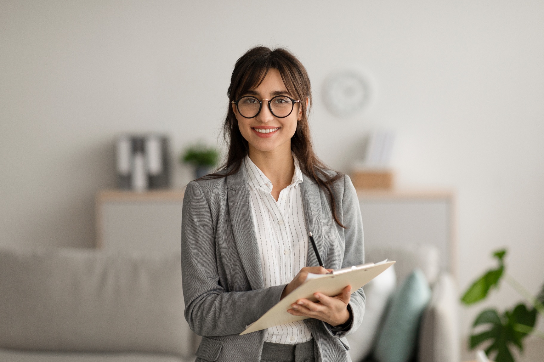 A woman smiles while holding a clipbaord. This could represent the support a therapist in Delray Beach, FL can offer. Learn more about Palm Beach County, FL therpay and other serivces by searching for online therapy in Florida today.