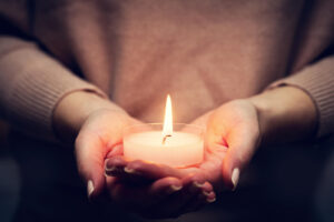 A close up of a person holding a candle in their hands. This could represent remembering loved ones and overcoming grief. Learn more about how EMDR in Palm Beach, FL can support you in overcoming grief. Contact an EMDR therapist in Palm Beach, FL today to learn more about EMDR therapy in Delray Beach, FL.