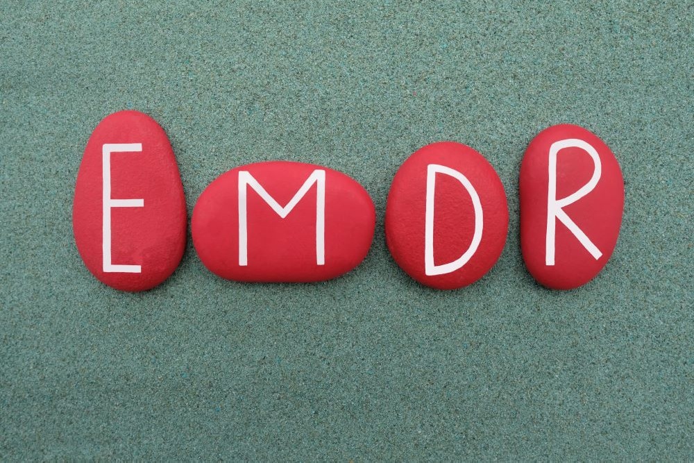 A close up of painted rocks with the letters EMDR on them. Learn how an EMDR therapist in Palm Beach County, FL can help you with overcoming past trauma. Contact a therapist in Delray Beach, FL to learn about EMDR in Palm Beach, FL and other services. 