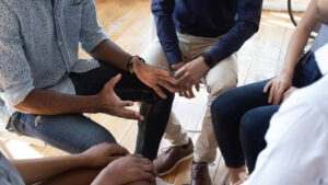 A close-up of people sitting in a circle while talking with each other. learn more about EMDR group therapy in Palm Beach County, FL and the benefits of working with an EMDR therapist in Palm Beach, FL today.