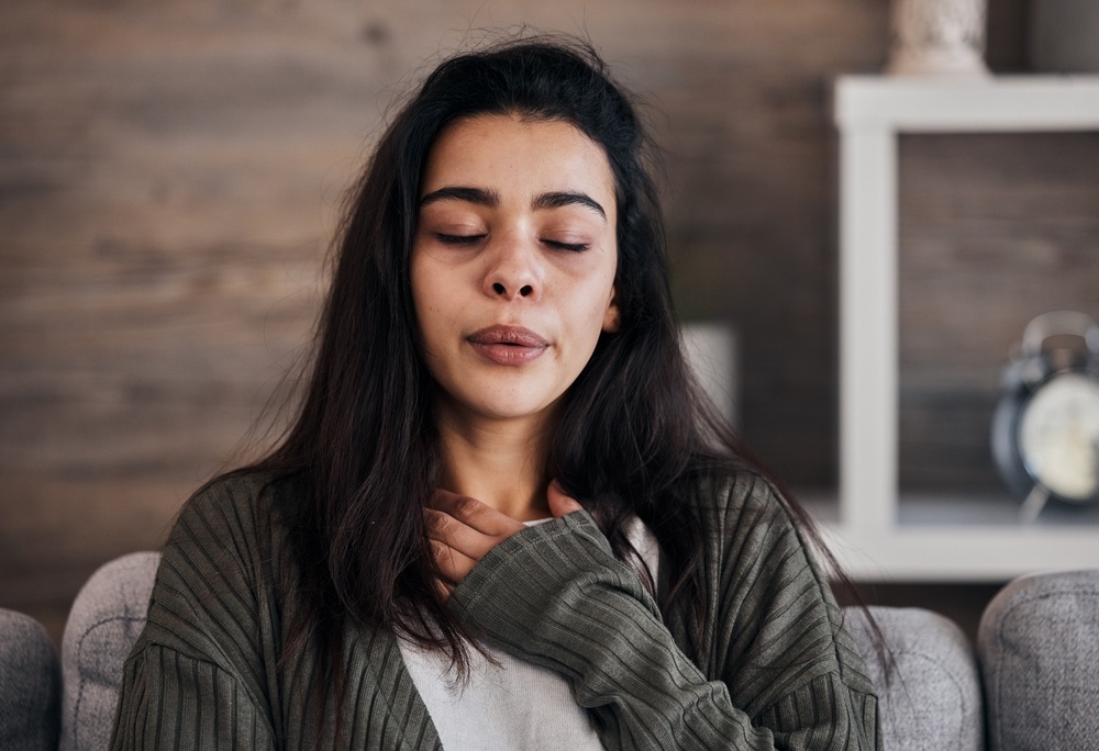 A woman practices breathing exercises while touching her chest. Learn how an anxiety therapist in Palm Beach County, FL can offer support via EMDR in Palm Beach County, FL. Search for how EMDR therapy in Delray Beach, FL can help today.