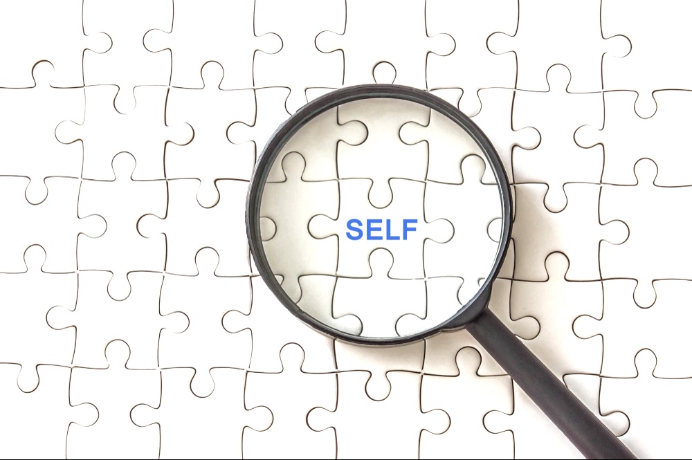 A close up of a magnifying glass over a puzzle piece that reads "self". Learn how about the help a trauma therapist in Delray Beach, FL can offer via EMDR therapy in Palm Beach, FL. Learn more about how an EMDR therapist in Palm Beach County, FL today. 