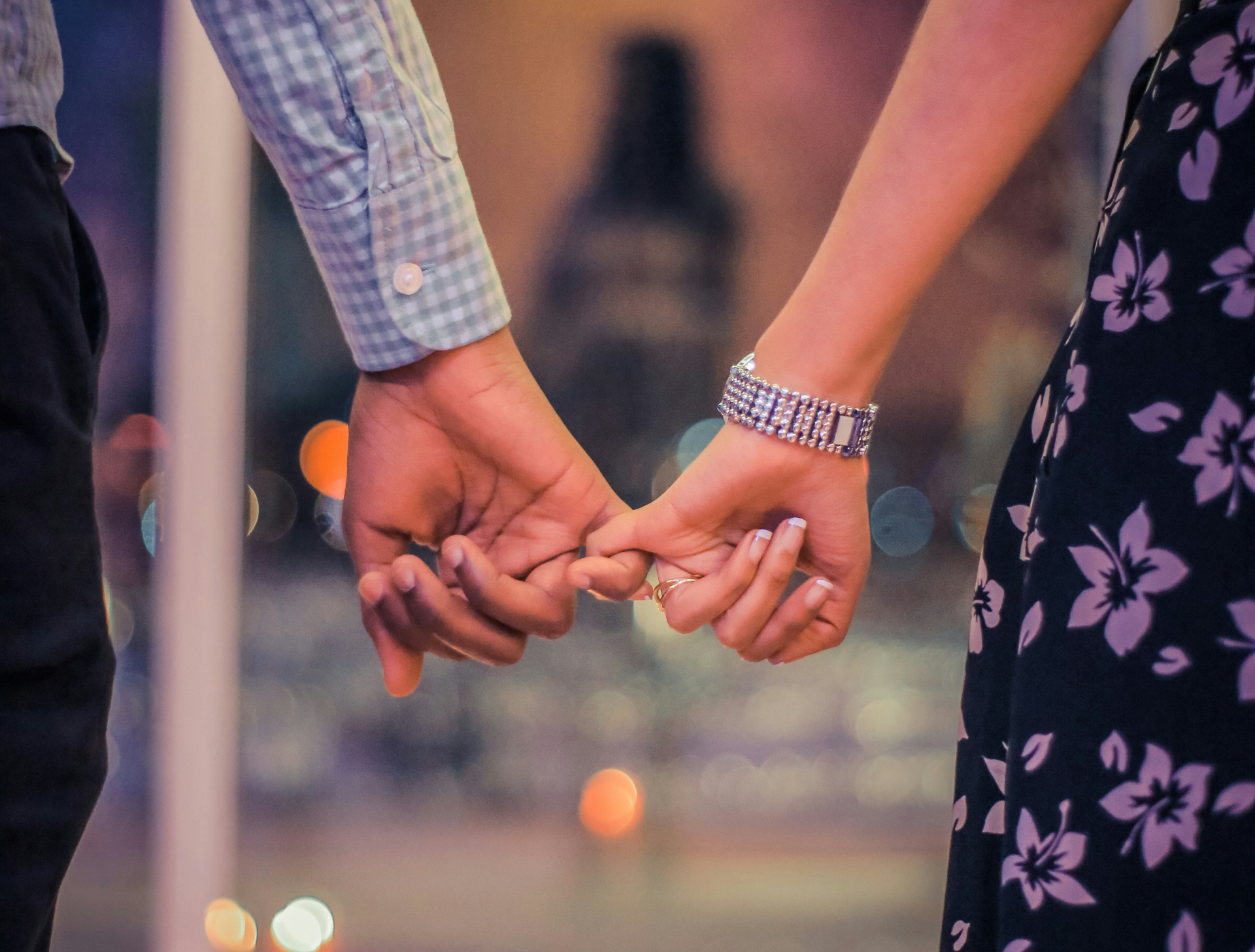 A close up of a couple holding hands by their pinkies. This could represent the bonds cultivated after working with a therapist in Palm Beach County, FL. Learn more about Palm Beach County, FL therapy by searching for online therapy in Florida.