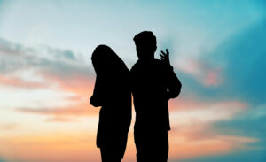 A silhouette of a couple standing back to back while appearing to argue. Leanr how a therapist in Palm Beach County, FL can offer remote support for your relationship via online therapy in Florida. Search for Delray Beach therapy to learn more today. 