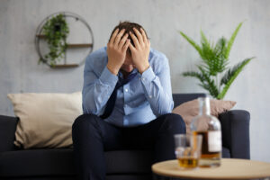 A man holds his head in his hands while sitting in front of a table with hard liquor in a glass. Learn how an addiction therapist in Palm Beach County, FL can offer support with addressing substance use. Search for substance abuse counseling in Delray Beach, FL for tips with different types of addiction in Palm Beach, FL. 