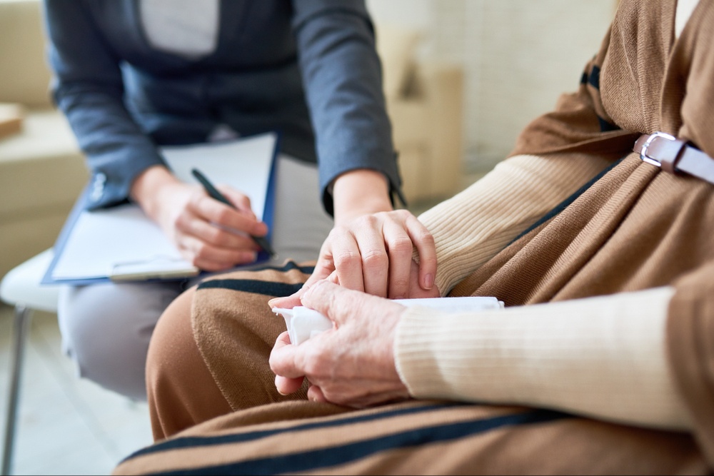 A close up of a person with a clipboard reaching out to a person in support holding a tissue. Learn how a grief counselor in Palm Beach County, FL can offer support with grief counseling in Delray Beach, FL and other services. Search for grief counseling in Delray Beach, FL to learn more. 