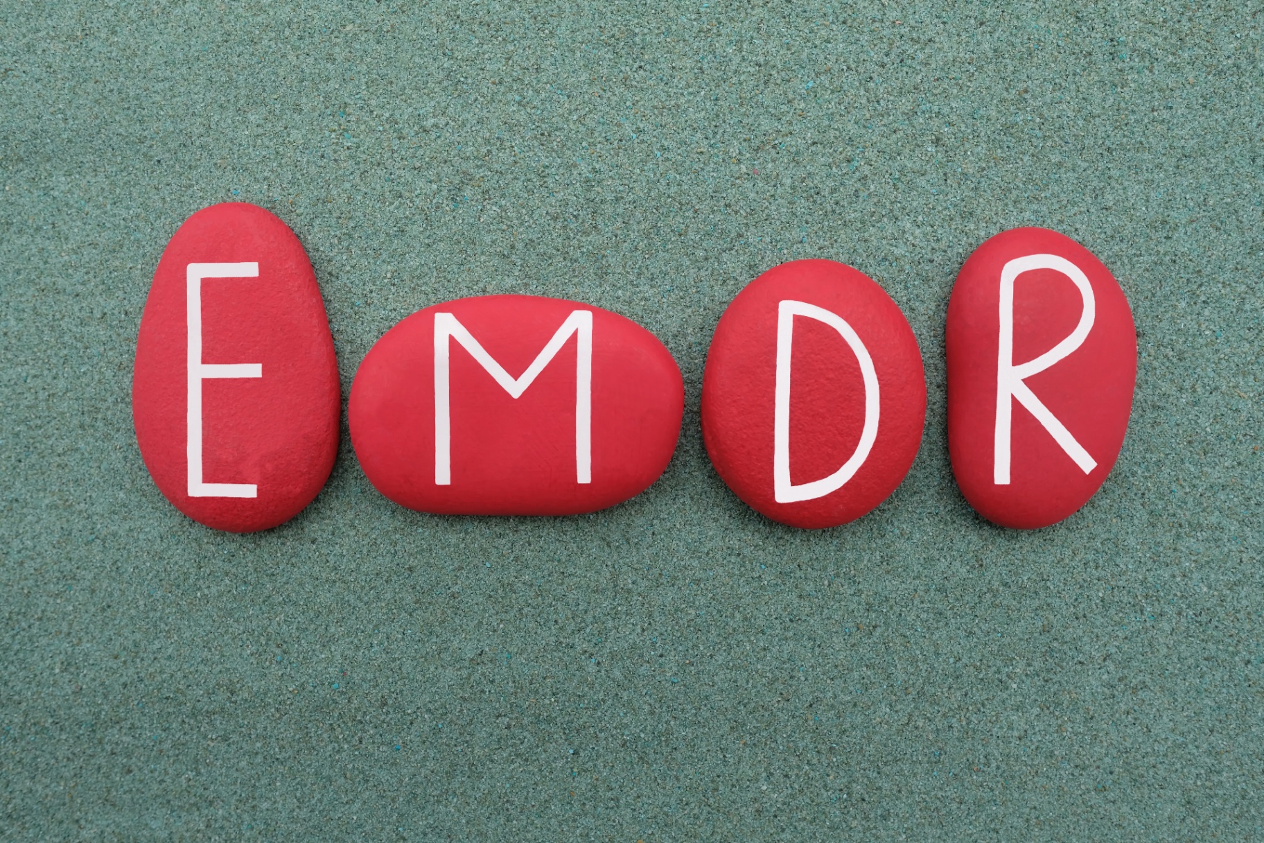 A close up of four red stones with the letters EMDR on them. Learn how EMDR in Palm Beach County, FL can offer support with training. Contact an EMDR therapist in Miami, FL or search for emdr therapy in Palm Beach, FL to learn more.